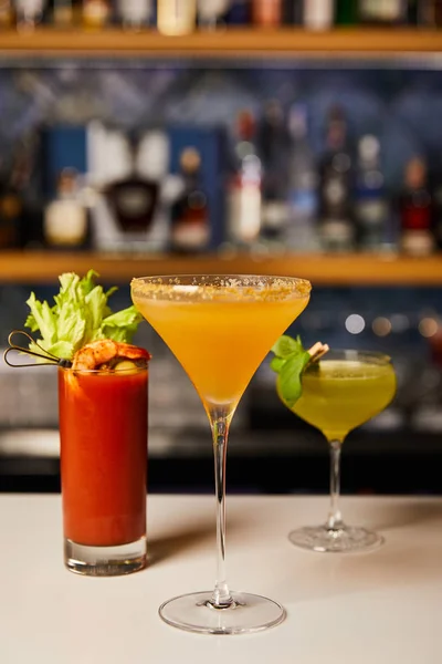 Selective focus of mixed and fresh cocktails in glasses on bar counter — Stock Photo