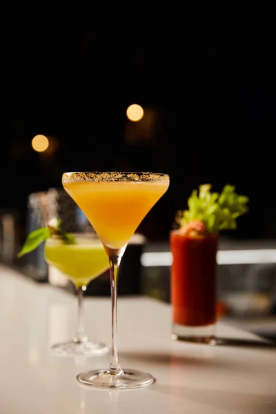Selective focus of fresh cocktails in glasses on bar counter — Stock Photo