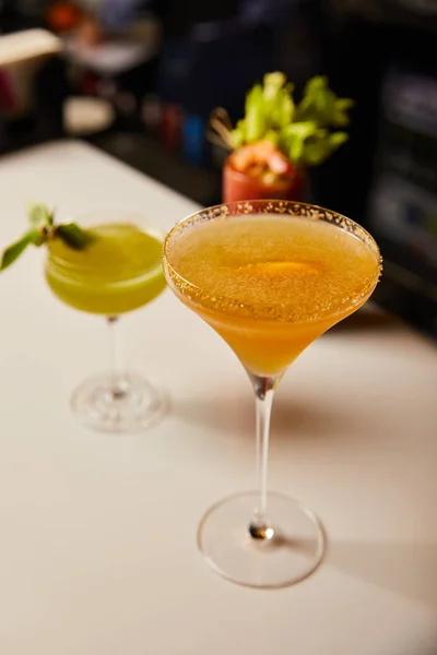 Selective focus of mixed cocktails in glasses on bar counter — Stock Photo