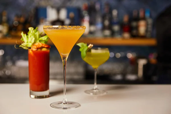 Selective focus of cold and fresh cocktails in glasses on bar counter — Stock Photo