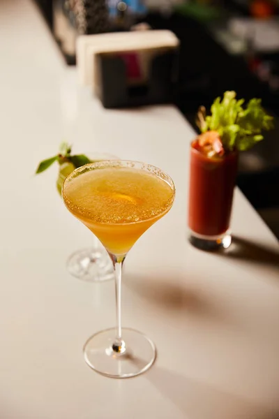 Selective focus of cold cocktails in glasses on bar stand — Stock Photo