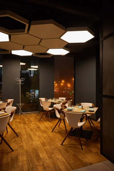 Gläser und Teller auf Holztischen im modernen Restaurant — Stockfoto
