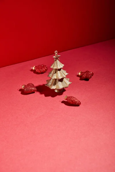 Albero di Natale dorato decorativo con bagattelle su sfondo rosso — Foto stock