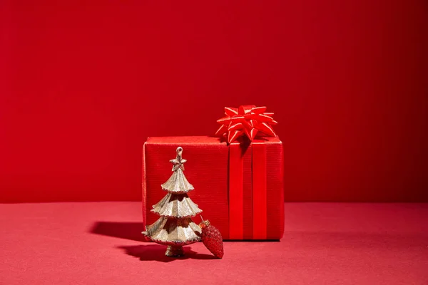 Caixa de presente vermelho e árvore de Natal dourada decorativa com bugiganga no fundo vermelho — Fotografia de Stock