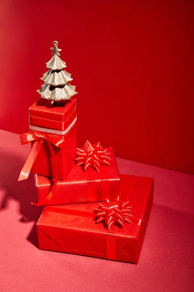 Caixas de presente vermelho e árvore de Natal dourada decorativa no fundo vermelho — Fotografia de Stock