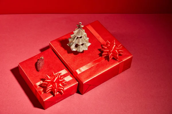 Caixas de presente vermelho e árvore de Natal dourada decorativa no fundo vermelho — Fotografia de Stock