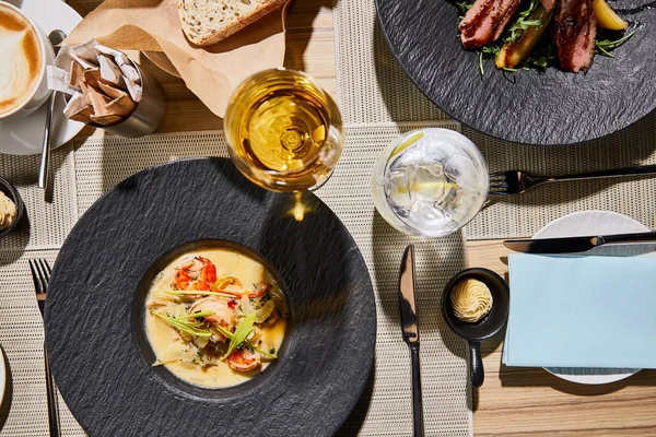 Top view of delicious restaurant dinner with seafood soup on wooden table — Stock Photo