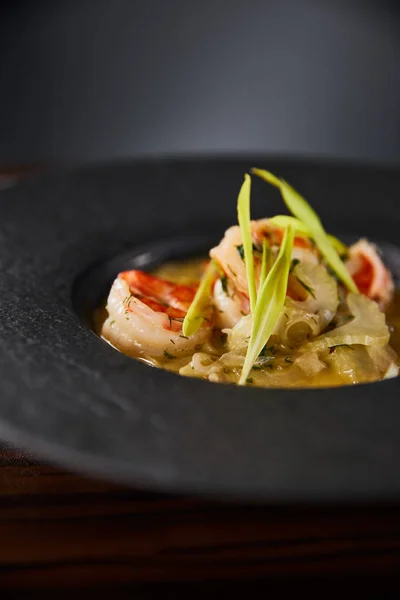 Nahaufnahme von köstlicher Restaurantsuppe mit Garnelen in schwarzem Teller — Stockfoto