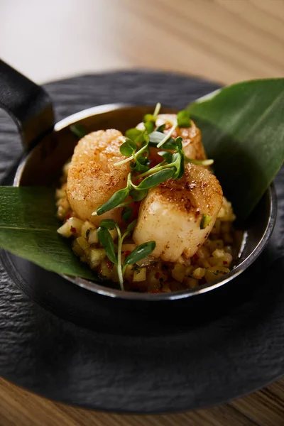 Delicious grilled scallops with green leaves and microgreens on wooden table — Stock Photo