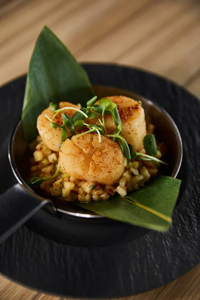 Delicious grilled scallops with green leaves and microgreens on wooden table — Stock Photo