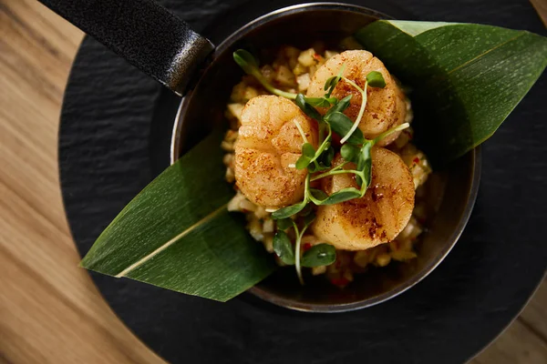 Top view of delicious grilled scallops with green leaves and microgreens on wooden table — Stock Photo