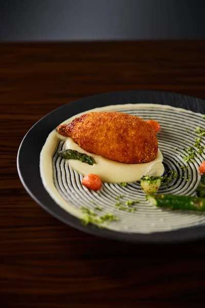 Delicioso pollo kiev y puré de papa servido en el plato en la mesa de madera - foto de stock