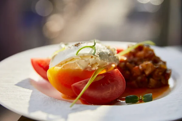 Delicious eggplant caviar with tomato and butter served in restaurant in sunlight — Stock Photo