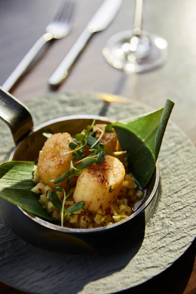 Deliciosas vieiras a la parrilla servidas en sartén con microgreens a la luz del sol - foto de stock