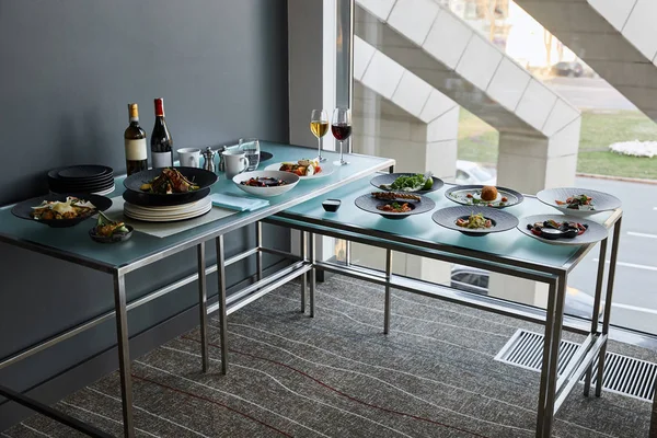 Bevande e piatti serviti ai tavoli di vetro nel ristorante per un pasto stand-up — Foto stock