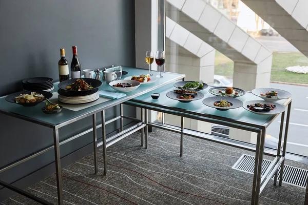 Beverages and dishes served at glass tables in restaurant for stand-up meal — Stock Photo
