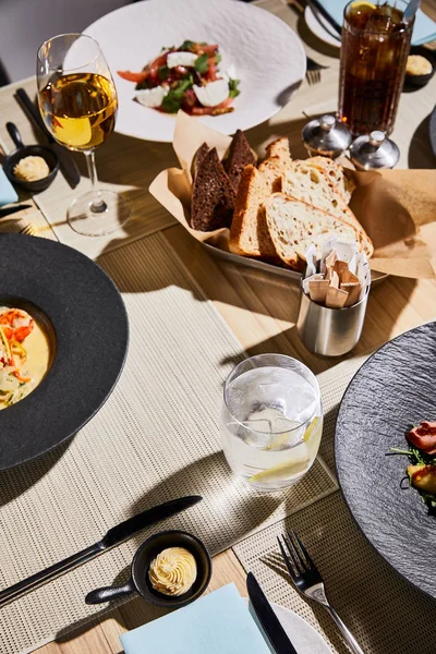 Delicious dishes served on table with beverages in restaurant — Stock Photo