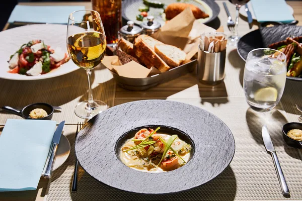 Deliciosa sopa com camarões servidos na mesa com bebidas no restaurante — Fotografia de Stock
