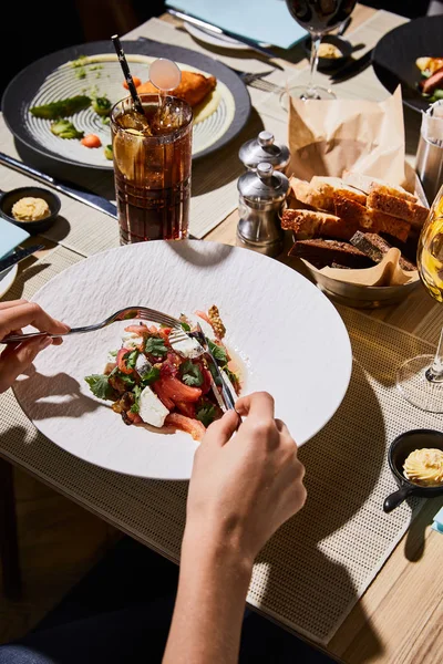 Vue partielle de la femme mangeant délicieux caviar d'aubergine au restaurant — Photo de stock