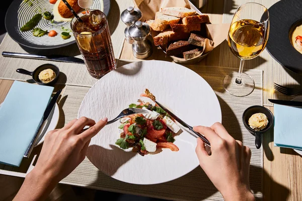 Cropped view of woman eating delicious eggplant caviar in restaurant — Stock Photo