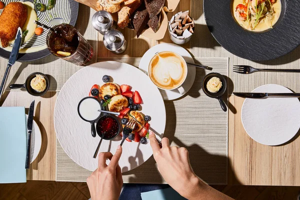 Von oben: Frau isst köstliche Syrniki im Restaurant — Stockfoto