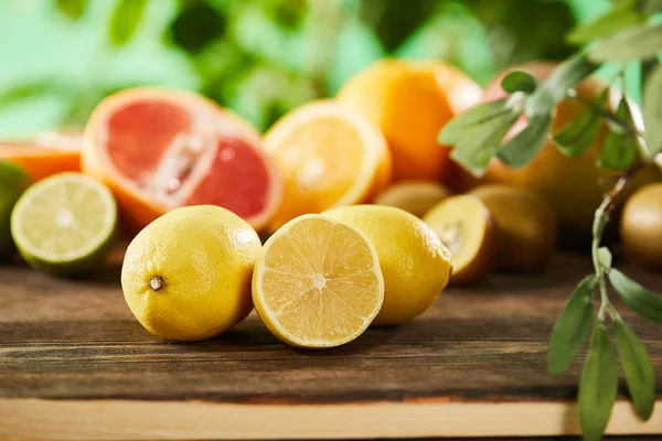 Messa a fuoco selettiva del taglio e dei limoni interi sulla superficie di legno — Foto stock