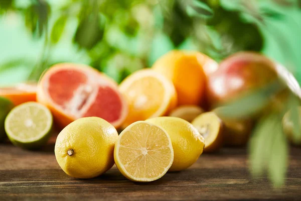 Selective focus of cut and whole lemons on wooden surface — Stock Photo