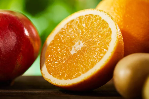 Vista de cerca de corte y naranjas enteras, granada y kiwi - foto de stock