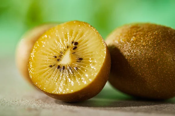 Close up view of cut and whole kiwi on marble surface — Stock Photo