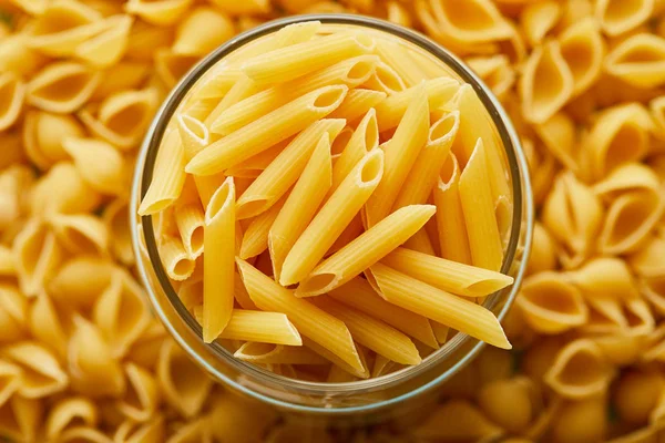 Draufsicht auf rohe Penne im Glas und Umgebung — Stockfoto