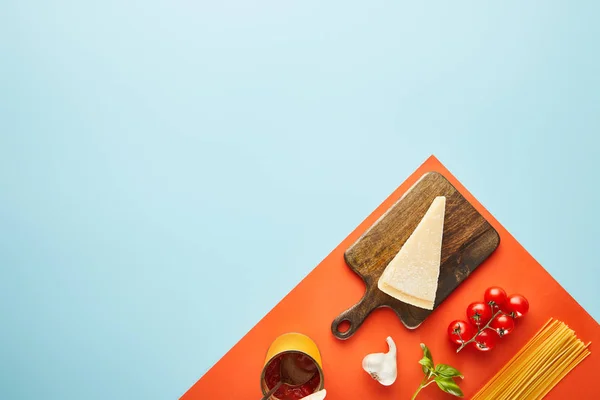 Flache Lage mit leckeren Nudeln mit Zutaten für Tomatensauce auf blauem, rotem Hintergrund — Stockfoto