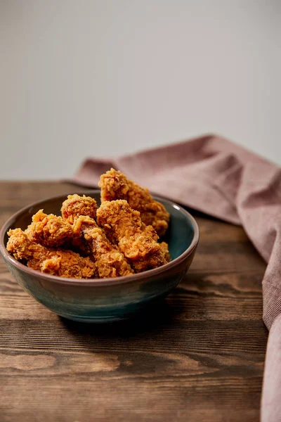 Deliziose pepite di pollo, ketchup, patatine fritte e cetriolini vicino a bicchieri di birra su tavolo di legno turchese isolato su grigio — Foto stock