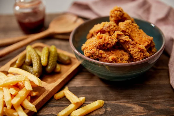 Selektiver Fokus auf leckere Chicken Nuggets, Pommes und Gurken auf Holztisch — Stockfoto