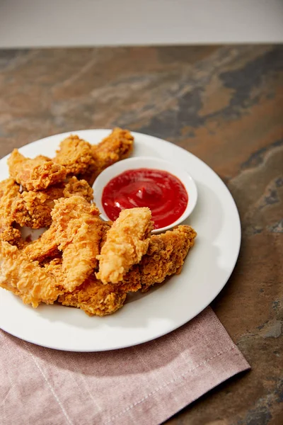 Deliciosas pepitas de pollo con salsa de tomate en la superficie de piedra - foto de stock