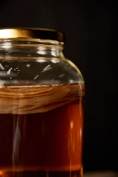 Glass jar with kombucha isolated on black — Stock Photo