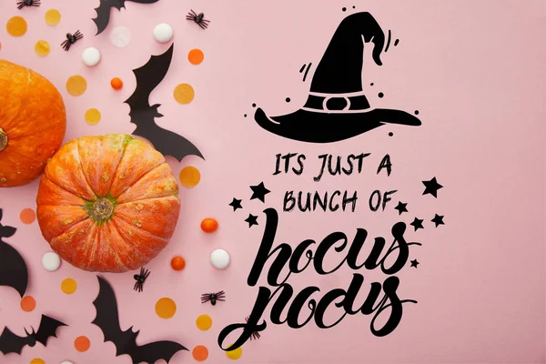 Top view of pumpkin, bats and confetti on pink background with its just a bunch of hocus pocus illustration — Stock Photo