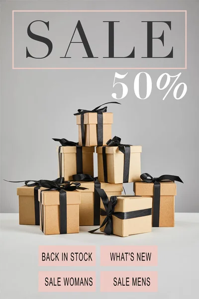 Cardboard gift boxes with black ribbons isolated on grey with sale 50 percent illustration, black Friday concept — Stock Photo