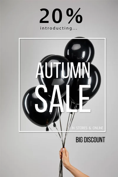 Partial view of woman holding bunch of black balloons isolated on grey with 20 percent autumn sale illustration, black Friday concept — Stock Photo
