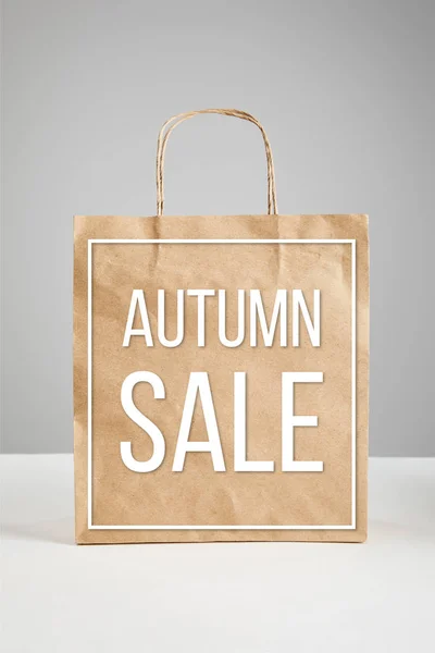 Paper shopping bag with autumn sale illustration isolated on grey, black Friday concept — Stock Photo