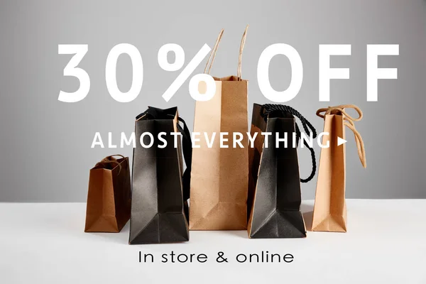 Paper shopping bags isolated on grey with 30 percent off almost everything illustration, black Friday concept — Stock Photo