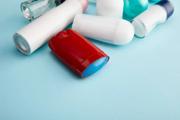 Rouler et vaporiser des bouteilles de déodorant sur fond bleu avec espace de copie — Photo de stock