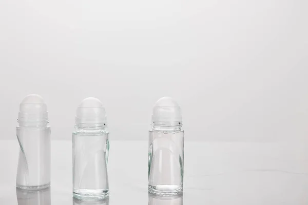 Transparent bottles of deodorant isolated on white — Stock Photo