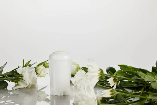 Enfoque selectivo de rollo en botella de desodorante con rosas aisladas en blanco - foto de stock