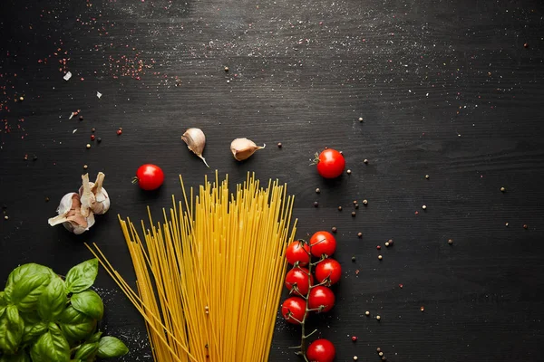 Top view of raw bolognese pasta ingredients on black wooden background — Stock Photo
