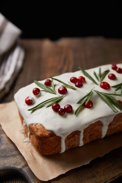 Close up view of traditional Christmas cake with cranberry and rosemary on wooden table isolated on black — Stock Photo