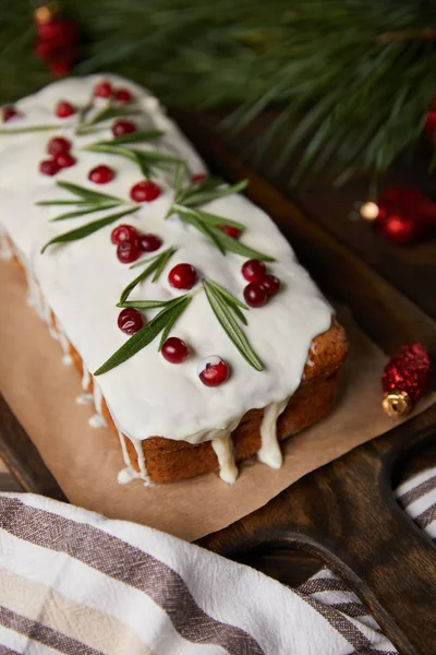 Foco seletivo do bolo de Natal tradicional com cranberry perto de ramo de pinho e guardanapo — Fotografia de Stock