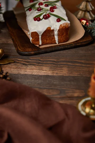 Traditional Christmas cake with cranberry on wooden table with brown napkin — Stock Photo