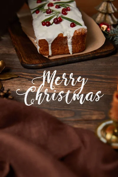 Традиційний різдвяний торт з журавлиною на дерев'яному столі з коричневою серветкою та білим веселим різдвяним листям — стокове фото
