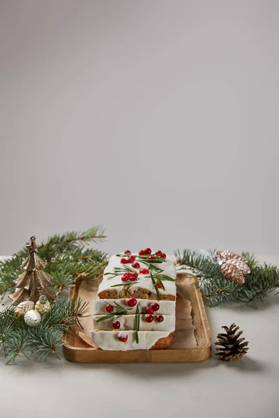 Pastel tradicional de Navidad con arándano cerca de chucherías y pino sobre mesa blanca aislado en gris — Stock Photo