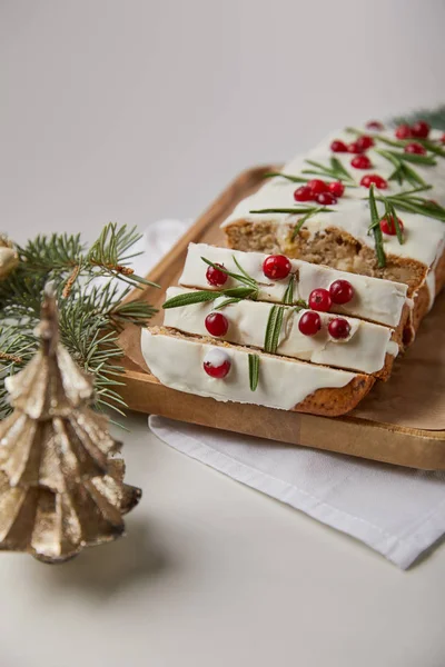 Selective focus of traditional Christmas cake with cranberry near bauble and pine on marble table isolated on grey — Stock Photo